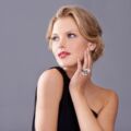 A gorgeous young woman in an evening gown while isolated on a grey background