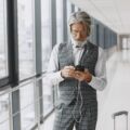 Senior businessman with travel suitcase in airport